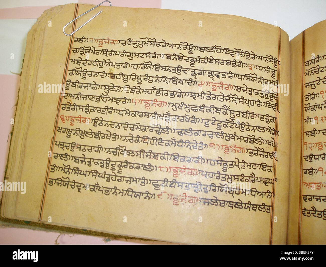 Questa vista dettagliata di un manoscritto gutka del XVIII secolo presenta una pagina del Dasam Granth, un testo sacro del sikhismo, che mostra l'estratto su piccola scala dei gurbani. Foto Stock