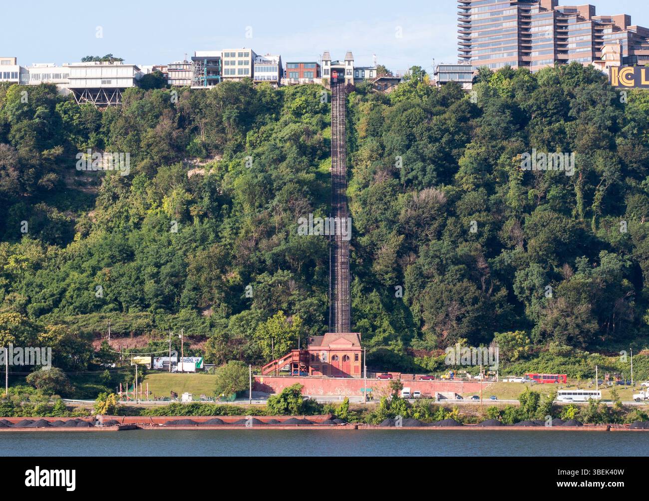 Una funicolare si arrampica sulla ripida collina, del Monte Washington, circondato da alberi lussureggianti ed edifici. Foto Stock