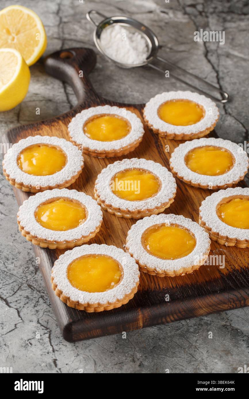 Deliziosi biscotti dolci al limone cosparsi di zucchero a velo sul tavolo. Verticale Foto Stock