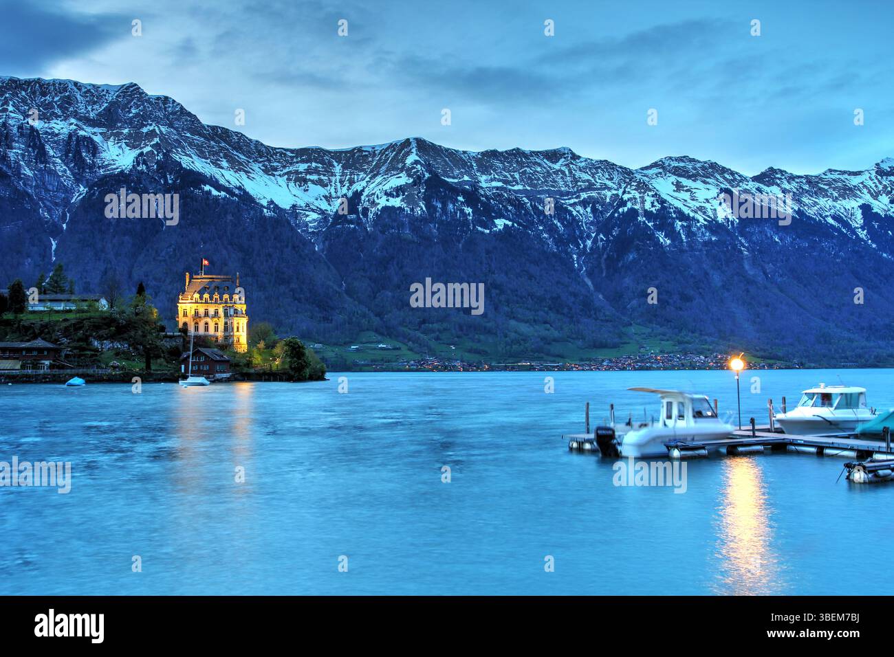 Montagne innevate sul castello di Seeburg a Iseltwald sul lago di Brienz (Brienzersee) di notte, Svizzera Foto Stock