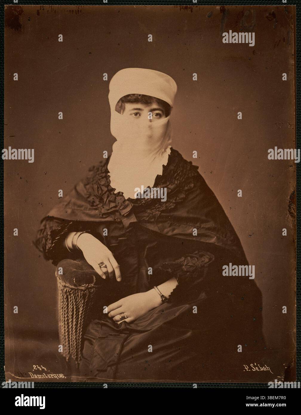 La fotografia di Pascal Sébah 'Dame turque' della fine del XIX secolo cattura l'eleganza di una donna turca in abiti tradizionali, simboleggiando la ricchezza culturale e lo stile fotografico del periodo ottomano. Foto Stock