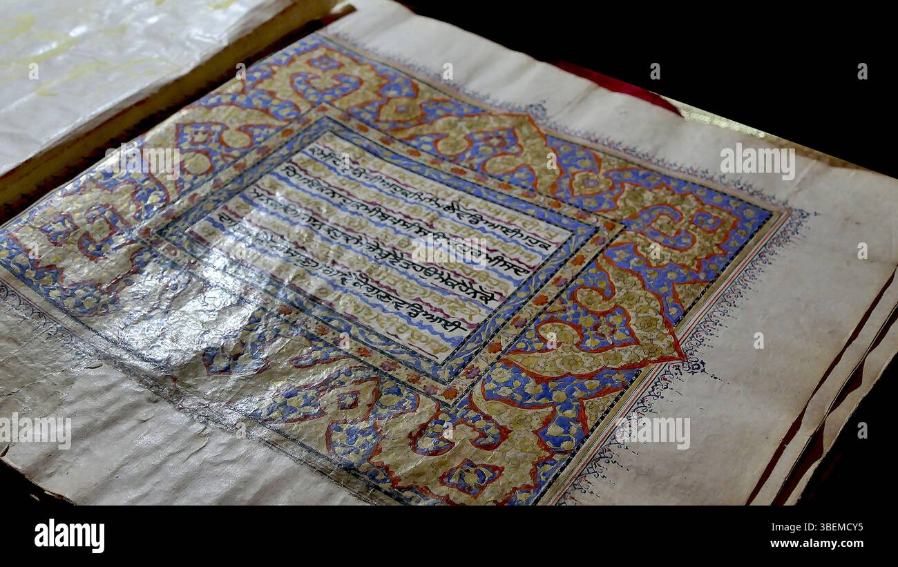 Il manoscritto "Sunehri bir", conservato a Gurdwara Mattan Sahib a Martand, Kashmir, India, risale al XVII secolo. Questo Guru Granth Sahib scritto a mano è un venerato testo religioso, creato da uno scriba e artista sconosciuto. Le fotografie furono scattate da Harkiran Kaur, mostrando l'importanza del manoscritto nel sikhismo. Foto Stock