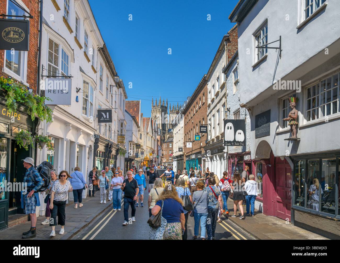 Negozi a Low Petergate guardando verso York Minster, York, North Yorkshire, Inghilterra, Regno Unito Foto Stock