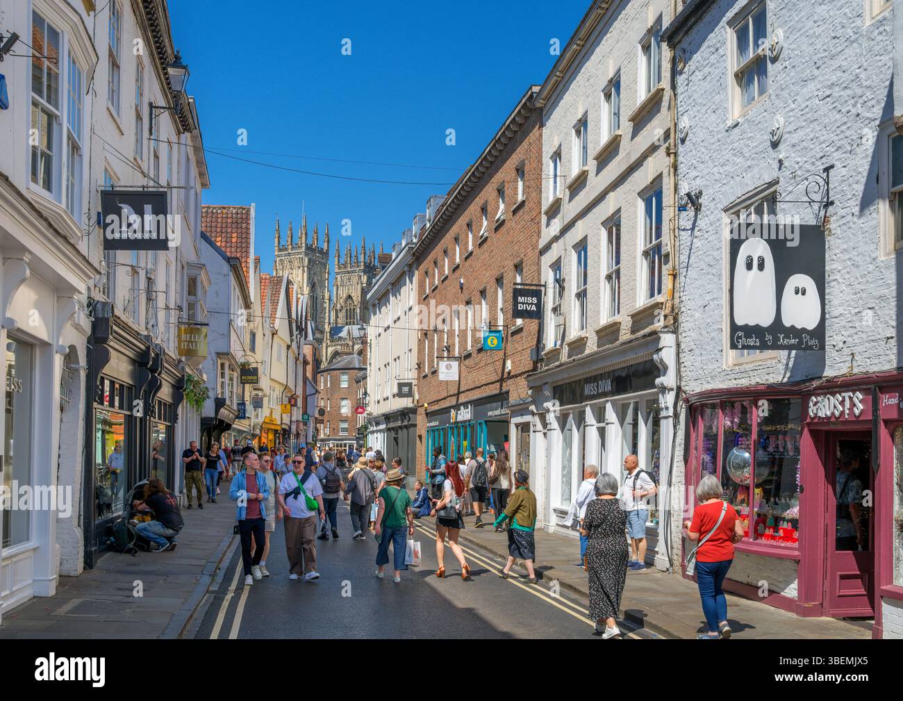 Negozi a Low Petergate guardando verso York Minster, York, North Yorkshire, Inghilterra, Regno Unito Foto Stock