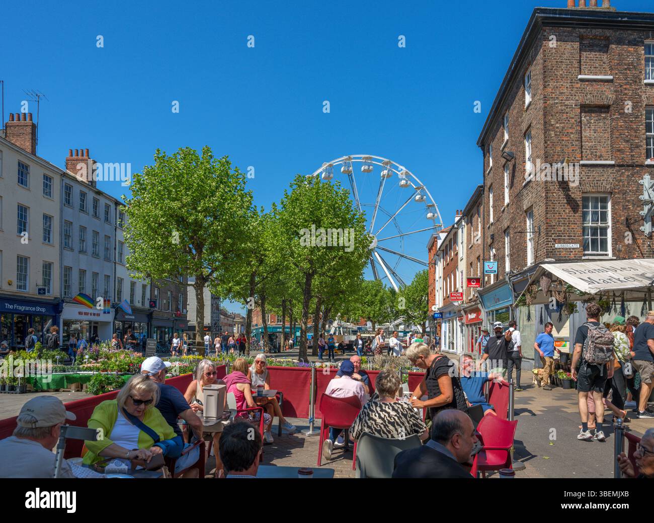 Caffè e negozi in Parliament Street con la ruota di York sullo sfondo, York, North Yorkshire, Inghilterra, Regno Unito Foto Stock