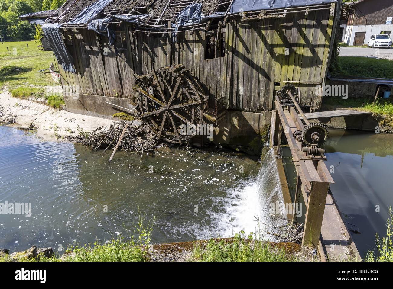 Storico mulino a martello sulla Rot vicino a Oberrot. L'edificio e la ruota ad acqua sono completamente rovinati. Oberrot, Baden-Wuerttemberg, Germania, Europa Foto Stock