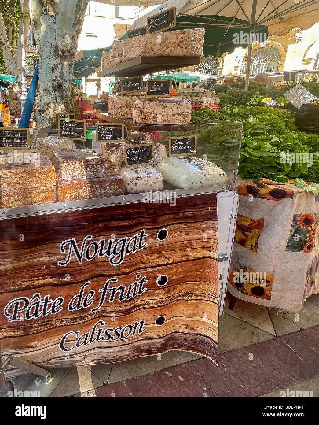 AIX-en-Provence, Francia - 10 luglio 2024: Negozio di torrone al mercato pubblico in Place Richelme. Grandi pezzi di gusti diversi in mostra. Vegetagles as neig Foto Stock