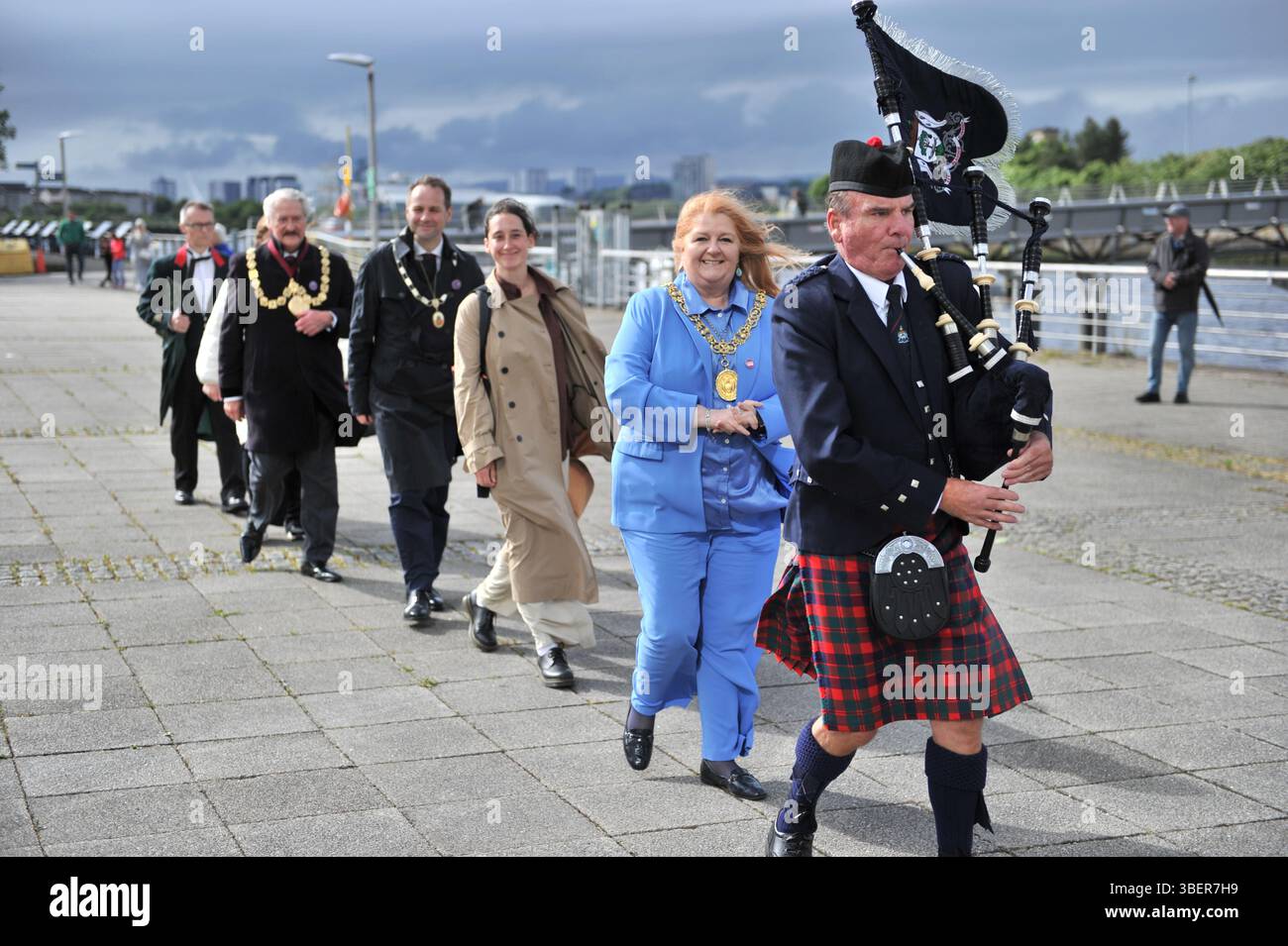 Glasgow, Regno Unito. 29 maggio 2025 - il Lord Provost di Glasgow viene visto con il suo pifferaio che conduce la strada durante la processione. Glasgow ha lanciato le celebrazioni di Glasgow 850 con la processione del Clyde Chorus a Pacific Quay. L'evento ha caratterizzato esibizioni dal vivo di Indepen-dance, YDance e pipe band, attraversando il Bell's Bridge per segnare l'inizio del festival musicale Clyde Chorus. Questo evento di tre giorni celebra il patrimonio e lo status di città della musica dell'UNESCO. Foto Stock