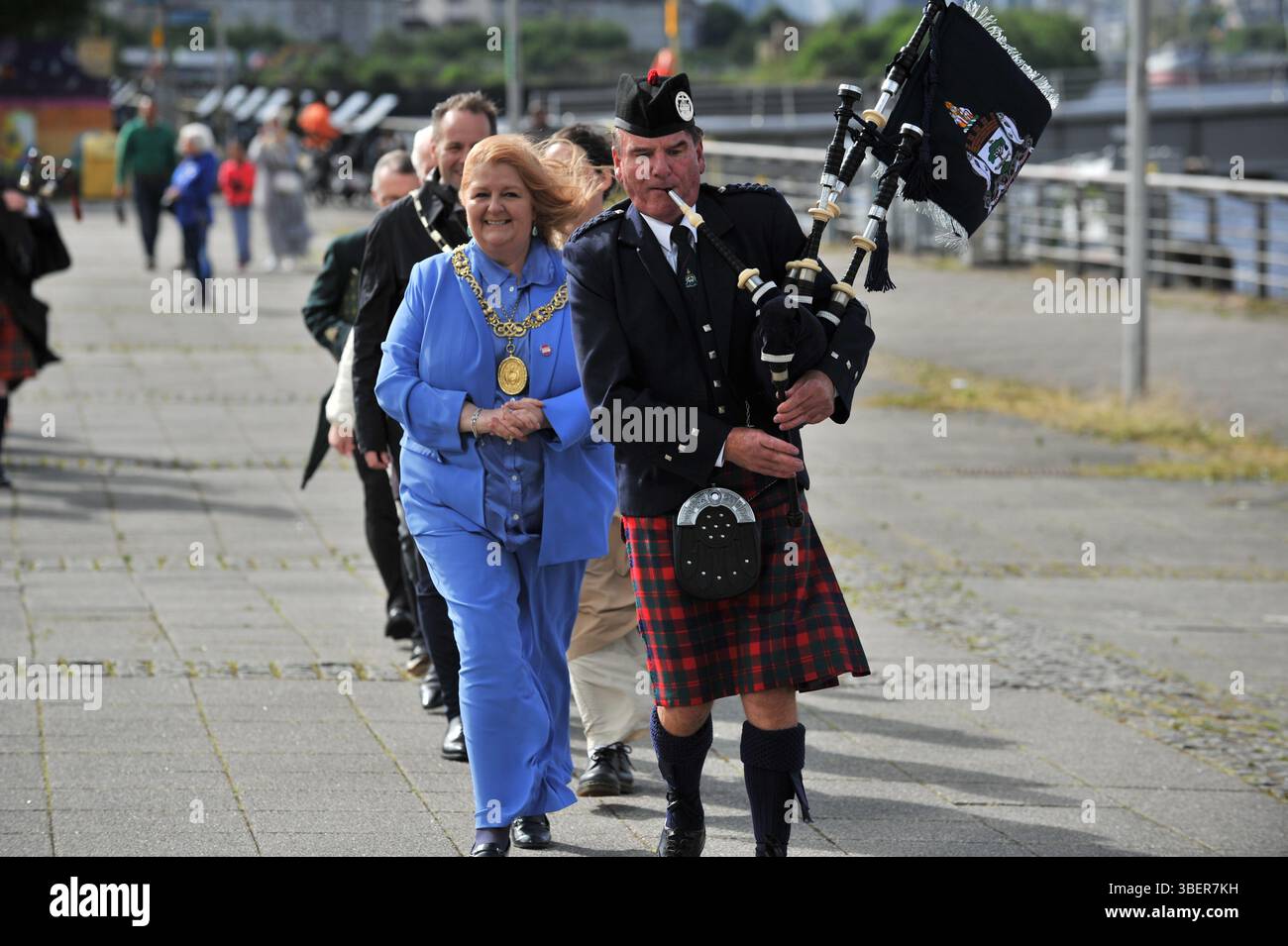 Glasgow, Regno Unito. 29 maggio 2025 - il Lord Provost di Glasgow e il suo pifferaio sono visti durante la processione seguiti da altri alti funzionari. Glasgow ha lanciato le celebrazioni di Glasgow 850 con la processione del Clyde Chorus a Pacific Quay. L'evento ha caratterizzato esibizioni dal vivo di Indepen-dance, YDance e pipe band, attraversando il Bell's Bridge per segnare l'inizio del festival musicale Clyde Chorus. Questo evento di tre giorni celebra il patrimonio e lo status di città della musica dell'UNESCO. Foto Stock