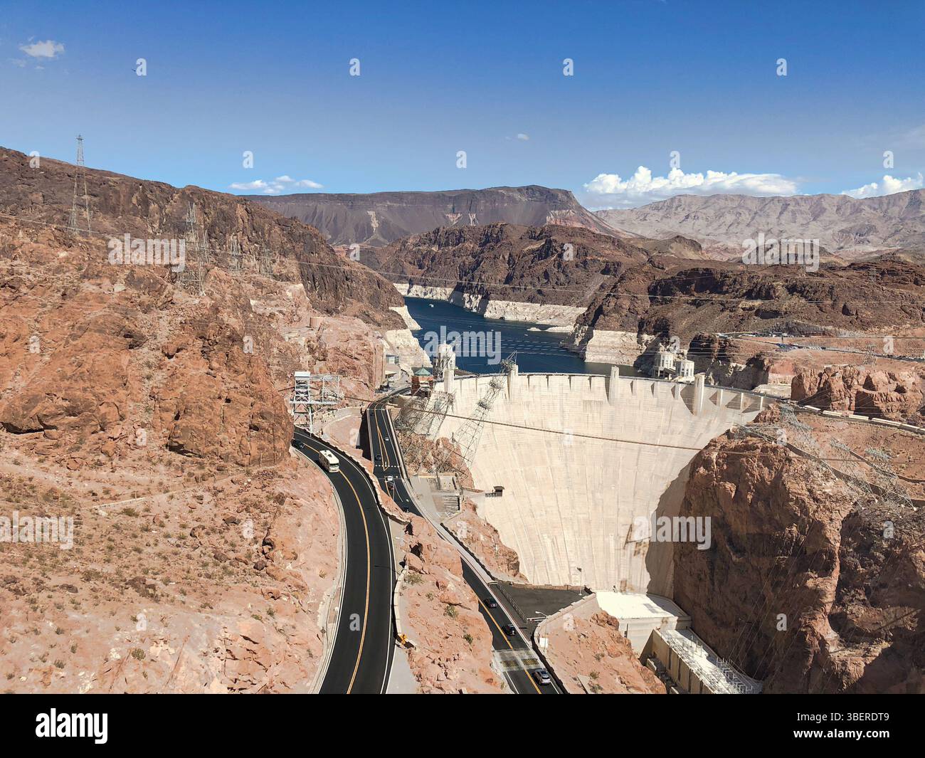 Vista aerea della diga di Hoover che attraversa il fiume Colorado in una giornata di sole, circondata da montagne aride e paesaggi desertici in Nevada e Arizona. - Immagine stock catturata con smartphone