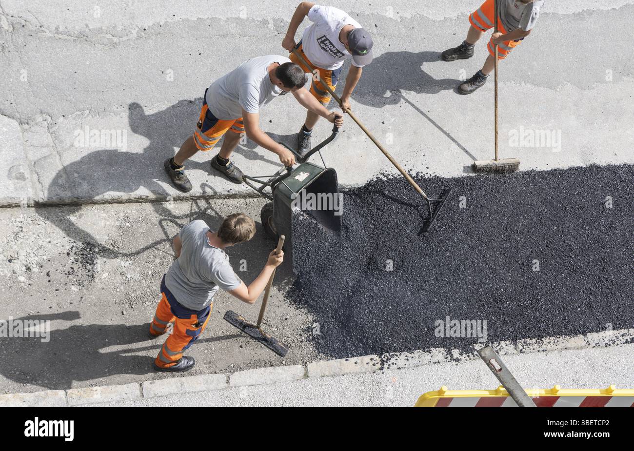 Operai, asfalto, superficie stradale, uomini. Carriola, rastrello, scopa Foto Stock