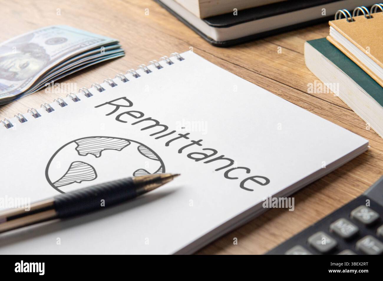 Notebook con la parola "rimessa", denaro e calcolatrice. Concetto finanziario. Foto Stock