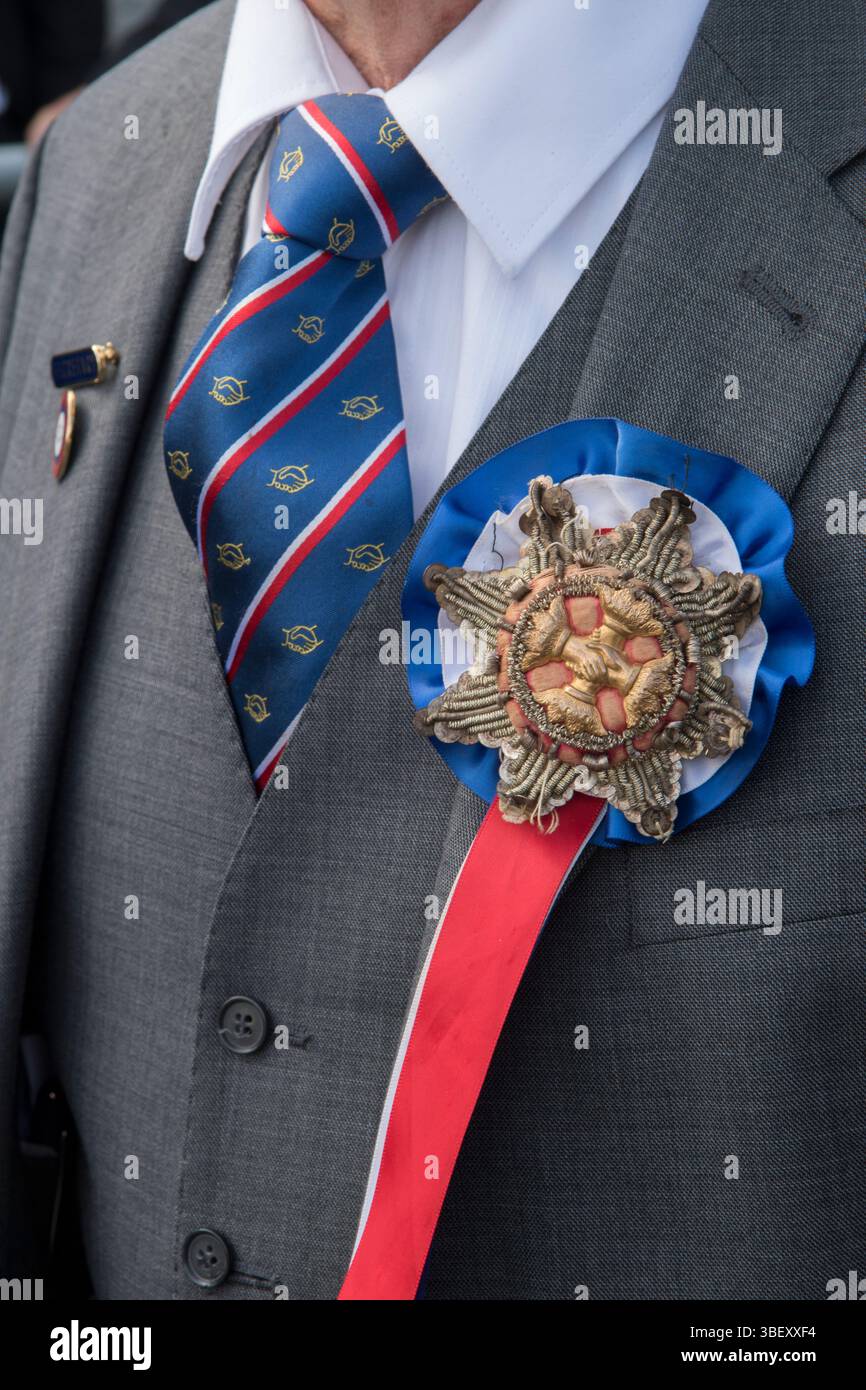 David Crossman, segretario della Long Sutton Friendly Society, indossa con orgoglio la speciale rosetta goffrata della società e il nastro rosso bianco e blu, un distintivo dell'ufficio. Long Sutton, Somerset, Inghilterra 2019 UK 2010s HOMER SYKES Foto Stock