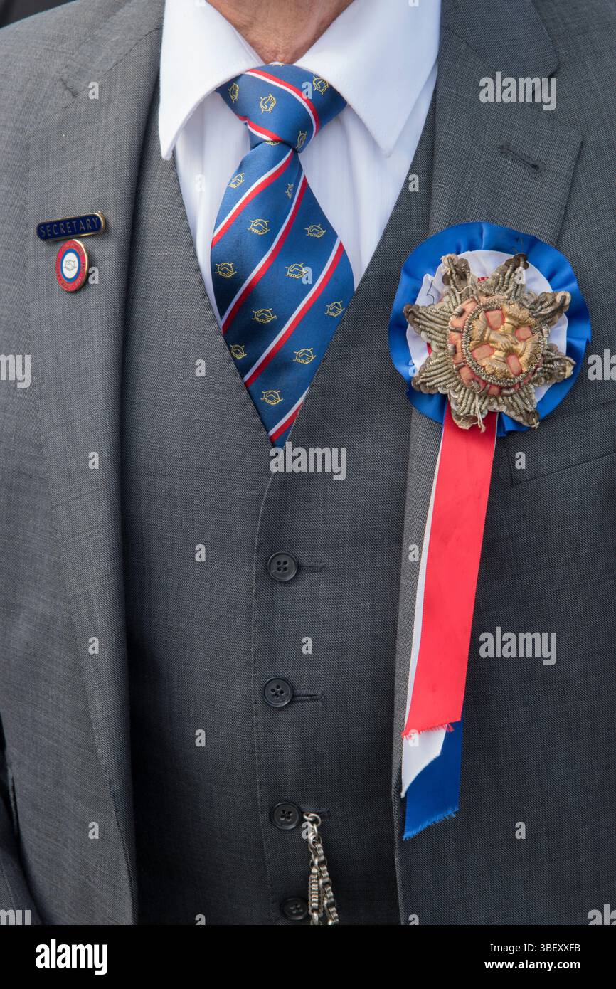 David Crossman, segretario della Long Sutton Friendly Society, indossa con orgoglio la rosetta in rilievo unica della società e il nastro rosso bianco e blu, un'insegna dell'ufficio. Long Sutton, Somerset, Inghilterra 2019 UK 2010s HOMER SYKES Foto Stock