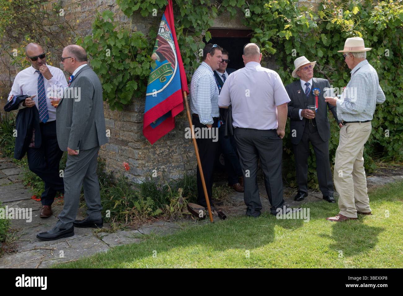 Friendly Societies UK. Il Long Sutton Friendly Society Club Walk Day annuale. Membri, è una società solo maschile che cammina in processione intorno al villaggio fermandosi in varie grandi case per rinfreschi. Birra in giardino con striscione. Long Sutton, Somerset, Inghilterra 2019 UK 2010s HOMER SYKES Foto Stock