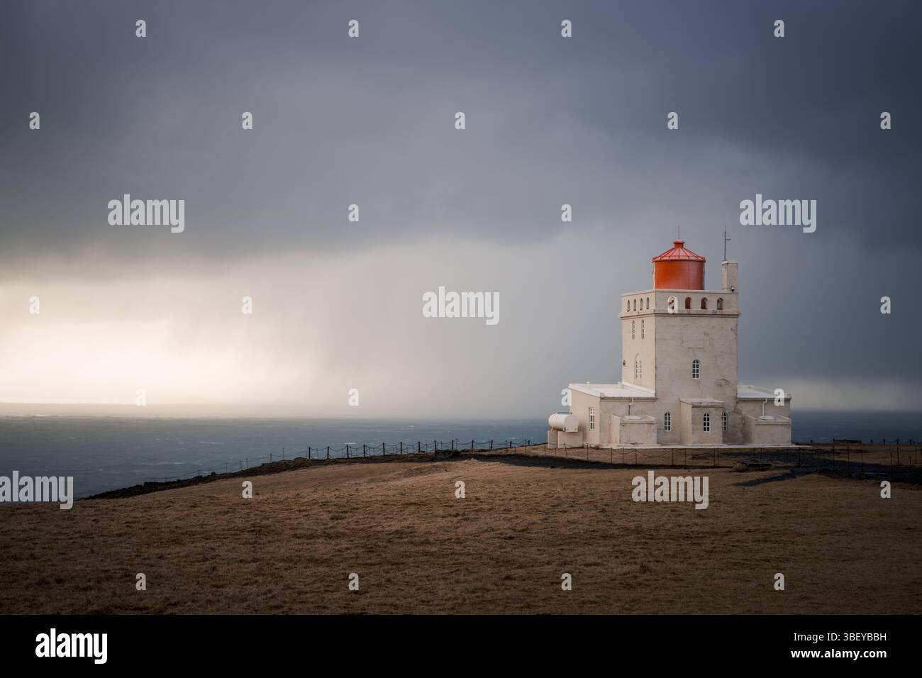 Il faro di Dyrholaey in una giornata tempestosa, costa meridionale dell'Islanda, regioni polari Foto Stock