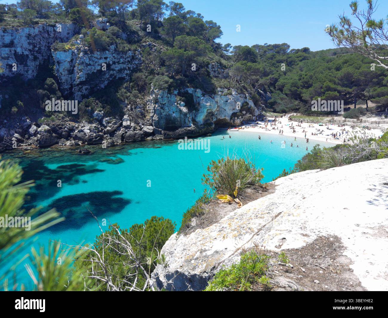 Cala Macarella, acque turchesi, mare trasparente, yacht galleggianti, pini, isole Baleari, spiaggia di Minorca, costa mediterranea, wat cristallino - Immagine stock catturata con smartphone