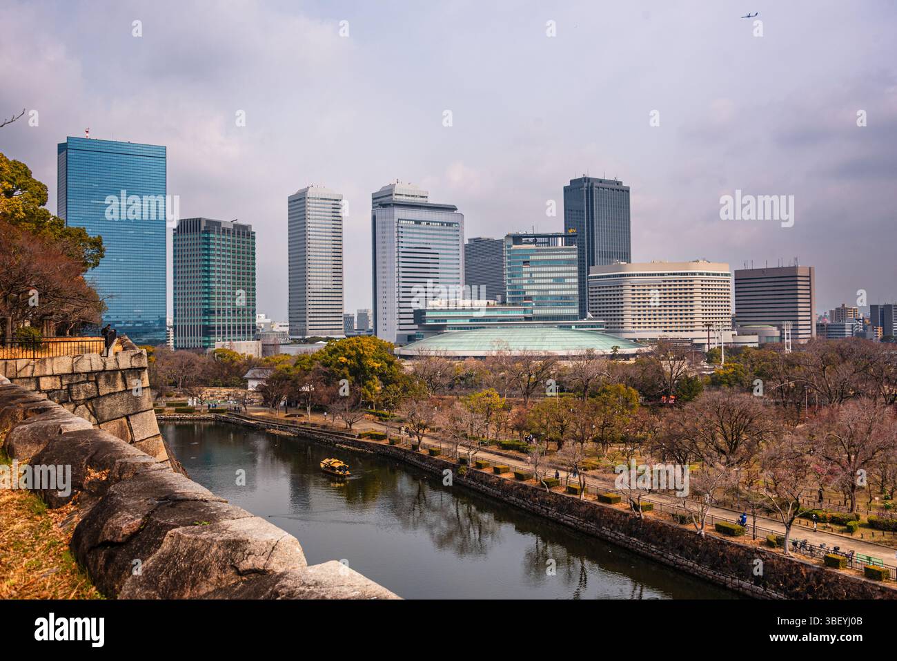 Affacciato sul fossato delle caste di fronte allo skyline del Parco finanziario di Osaka. Castello di Osaka, Osaka, Kansai, Giappone Foto Stock