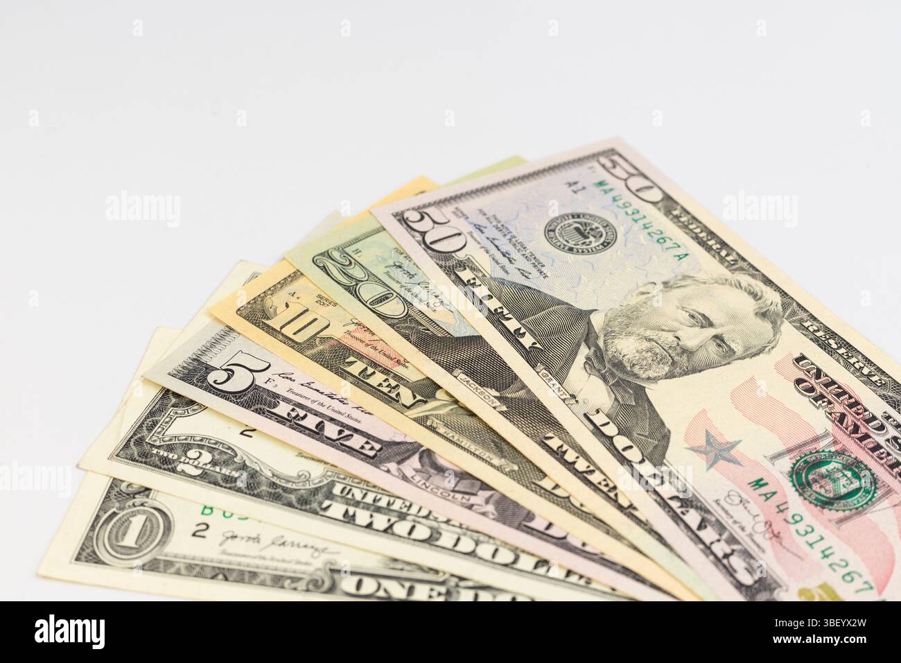 Banconote in dollari dello Stato d'America di varia denominazione su sfondo bianco isolato con spazio di copia Foto Stock