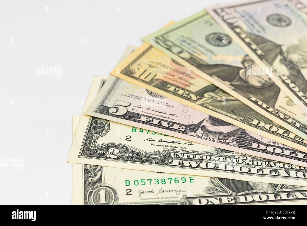 Serie di varie banconote in dollari USA distribuite su sfondo bianco Foto Stock