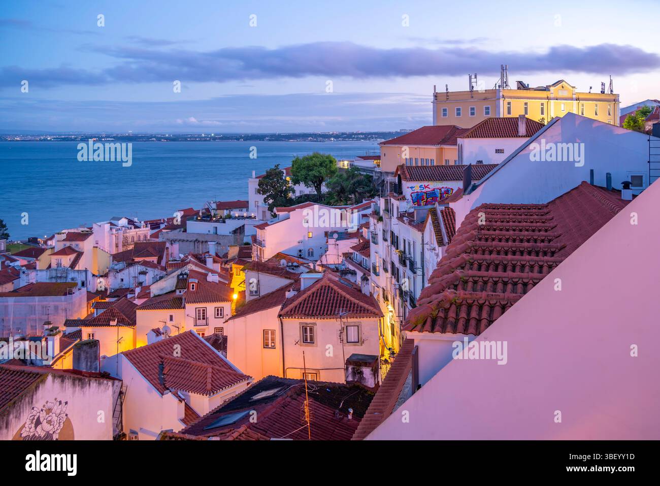 Vista di edifici colorati e tetti rossi al crepuscolo nel quartiere di Alfama, Lisbona, Portogallo, Europa Foto Stock