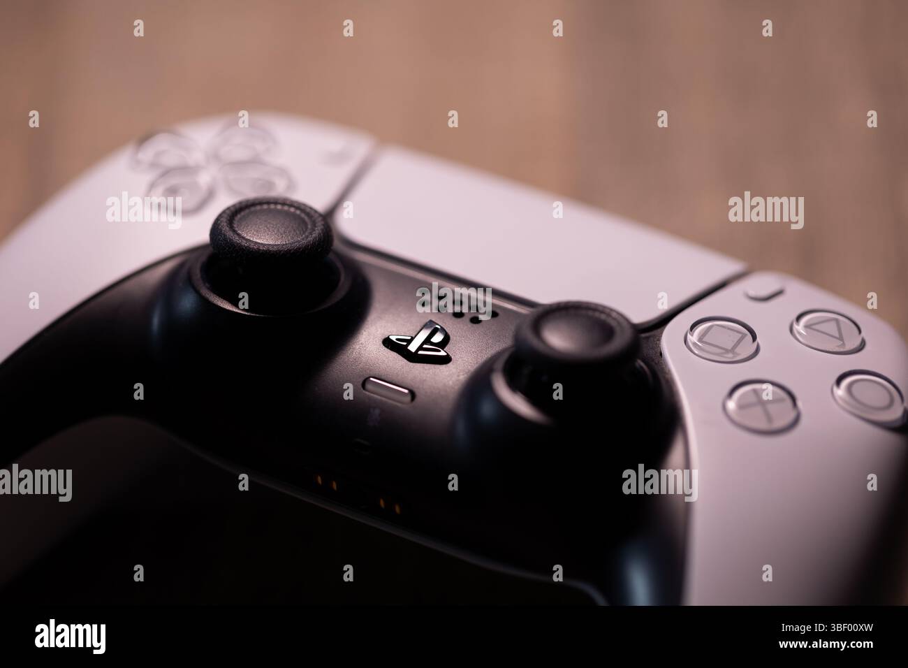 Brecht, Belgio - 18 aprile 2025: Ritratto di un controller wireless sony playstation 5 originale bianco appoggiato su un tavolo di legno. Pronto a giocare con PS5 co Foto Stock
