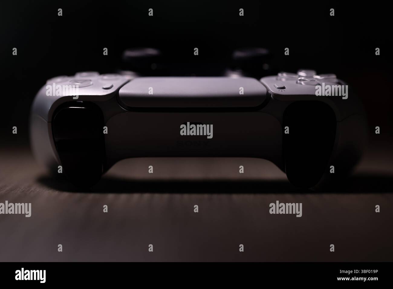 Brecht, Belgio - 18 aprile 2025: Un ritratto completo di un controller wireless originale bianco sony playstation 5 appoggiato su un tavolo di legno. Pronti a giocare a P Foto Stock