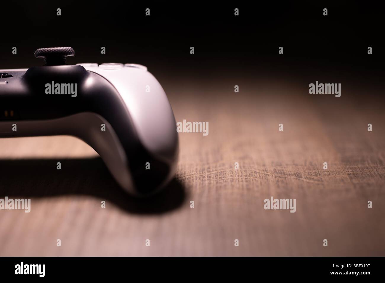 Brecht, Belgio - 18 aprile 2025: Un ritratto ravvicinato di metà di un controller wireless originale bianco sony playstation 5 appoggiato su un tavolo di legno. Pronti Foto Stock