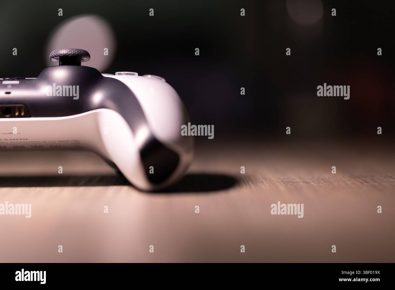Brecht, Belgio - 18 aprile 2025: Ritratto di metà di un controller wireless originale bianco sony playstation 5 appoggiato su un tavolo di legno. Pronti a giocare Foto Stock