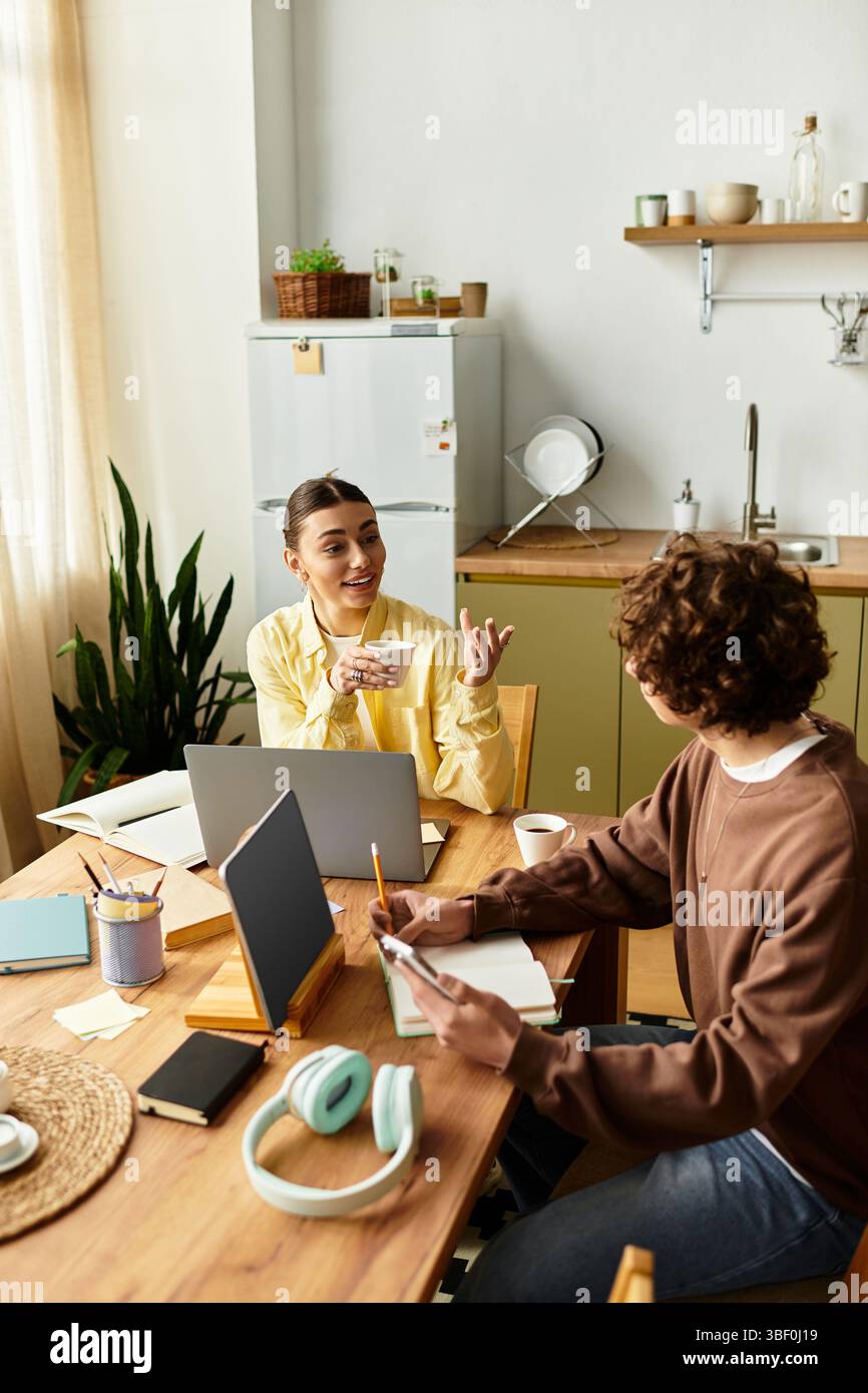 Una coppia amorevole condivide risate e conversazioni mentre lavora sui loro progetti in una cucina calda. Foto Stock