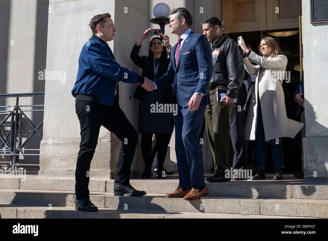 Il Segretario alla difesa Pete Hegseth stringe la mano a Elon Musk mentre esce dal Pentagono, Washington, D.C., 21 marzo 2025. (Foto DOD di Madelyn Keech, Senior Airman dell'aeronautica militare statunitense) Foto Stock