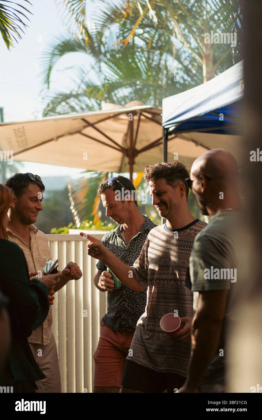 Amici che ridono e socializzano a una festa all'aperto Foto Stock