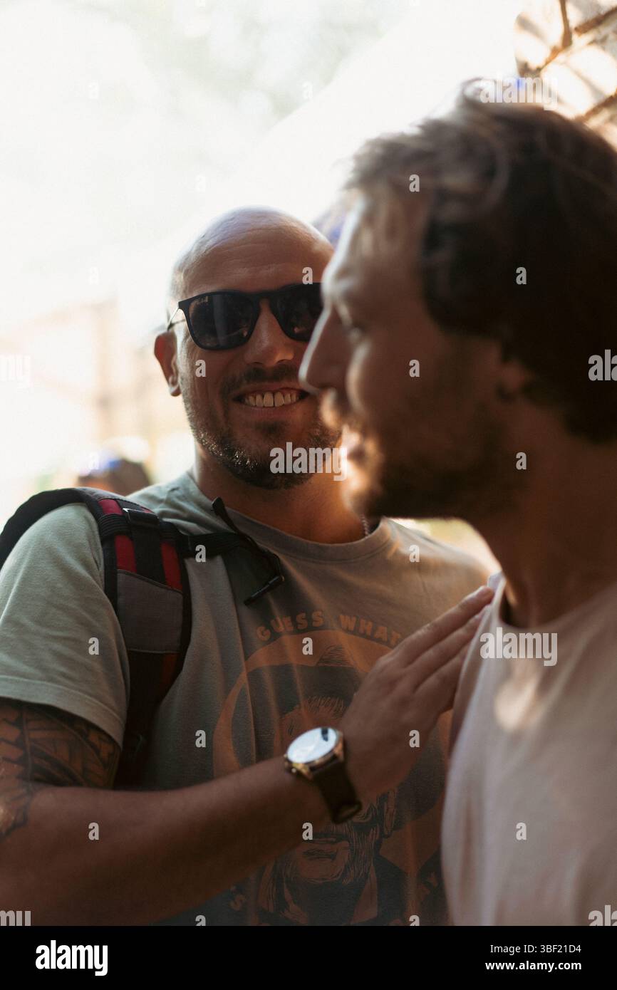 Due uomini che condividono un momento di amicizia in un evento all'aperto Foto Stock