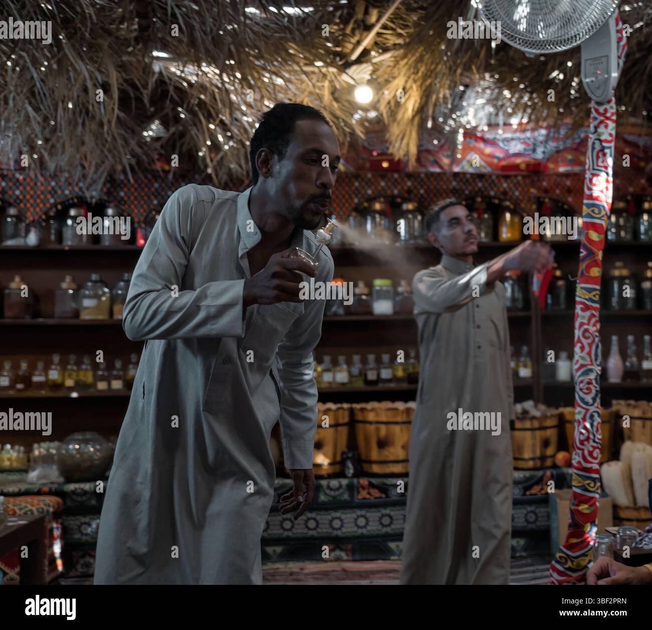 Cairo, Egitto - 11 settembre 2023: Una scena accogliente in una caffetteria egiziana che mostra tradizioni culturali e atmosfera autentica, mettendo in risalto gli uomini che si preparano Foto Stock