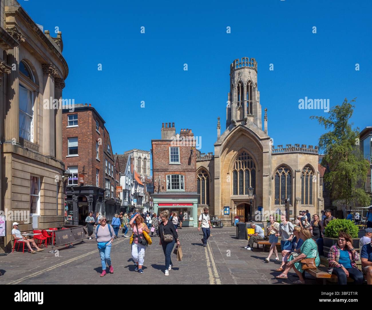 Negozi su St Helens Square che guardano verso St Helen Stonegate Church, York, North Yorkshire, Inghilterra, Regno Unito Foto Stock