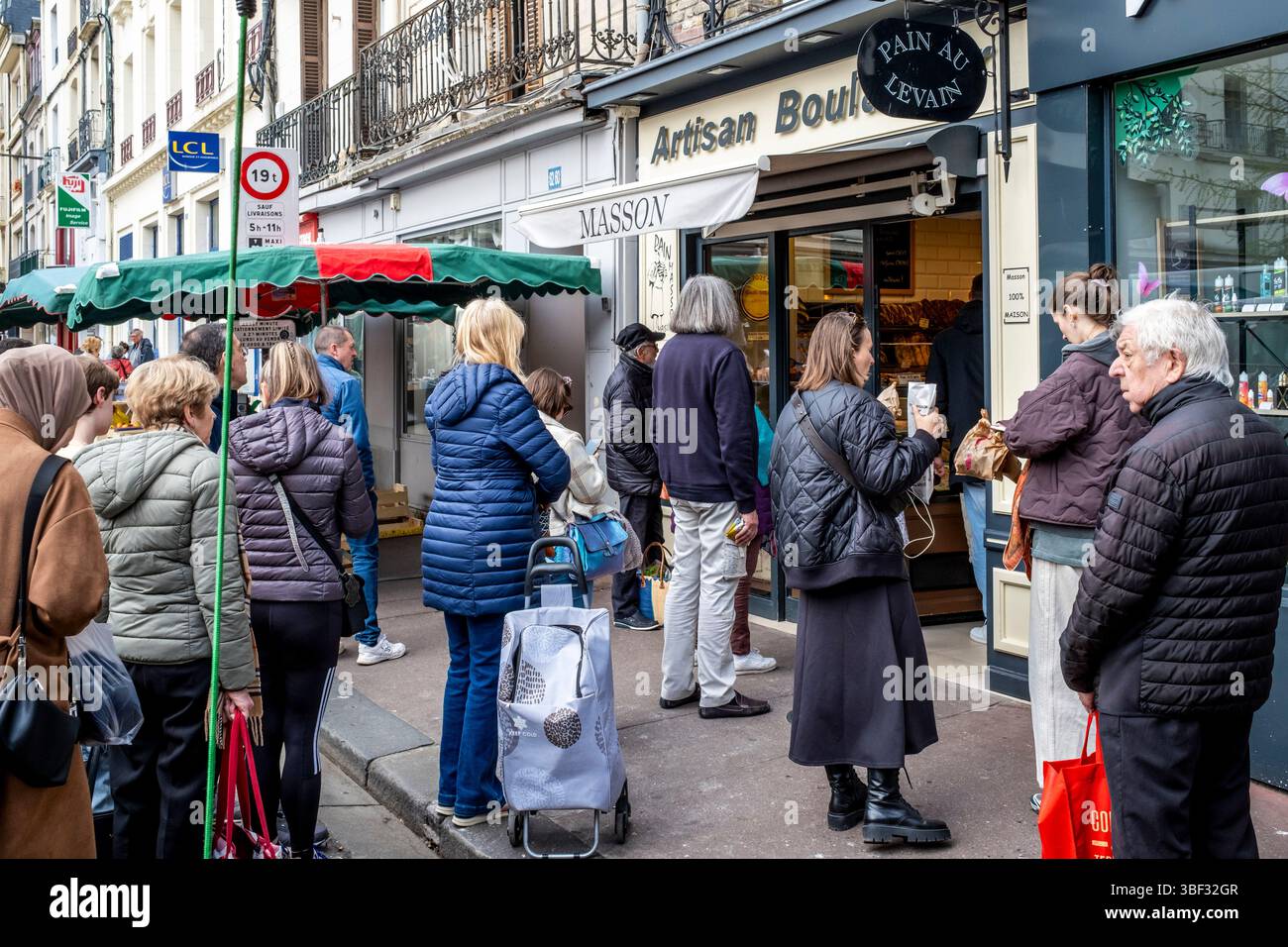 Gente del posto che fa la coda fuori Da Una Boulangerie (panetteria) al mercato del sabato a Dieppe, dipartimento marittimo della Senna, Francia. Foto Stock