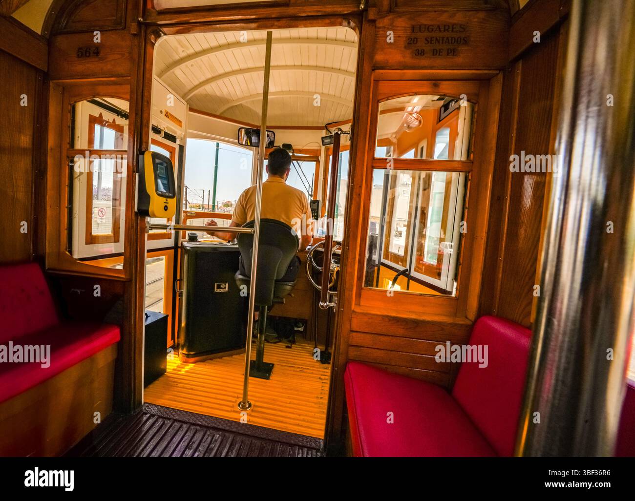 Autista ai comandi di uno storico tram 18E di Lisbona, che cattura gli interni vintage e il fascino senza tempo di uno dei trasporti più iconici del Portogallo. Foto Stock