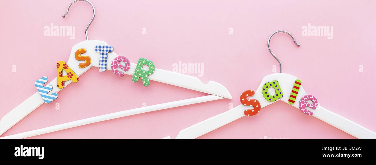 Creative vista superiore piatto bianco laici i portabiti in legno vendita testo rosa pastello con sfondo spazio copia stile minimalista. Il modello femminile di moda blog soci Foto Stock