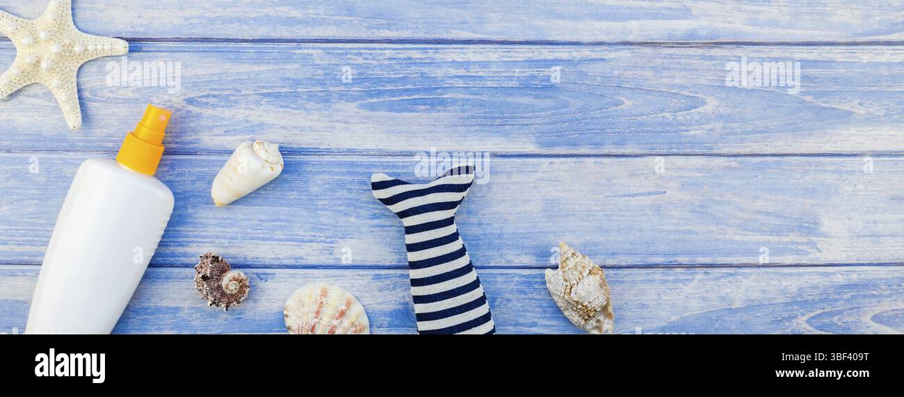 Lungo banner largo piatto concetto laici estate vacanze di viaggio. Vista superiore della bottiglia per la protezione solare mockup conchiglie e stelle marine blu pastello doghe in legno backgr Foto Stock