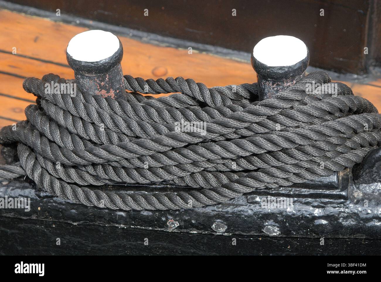 Corda a spirale ordinata su una tacca sul ponte di una nave storica Foto Stock