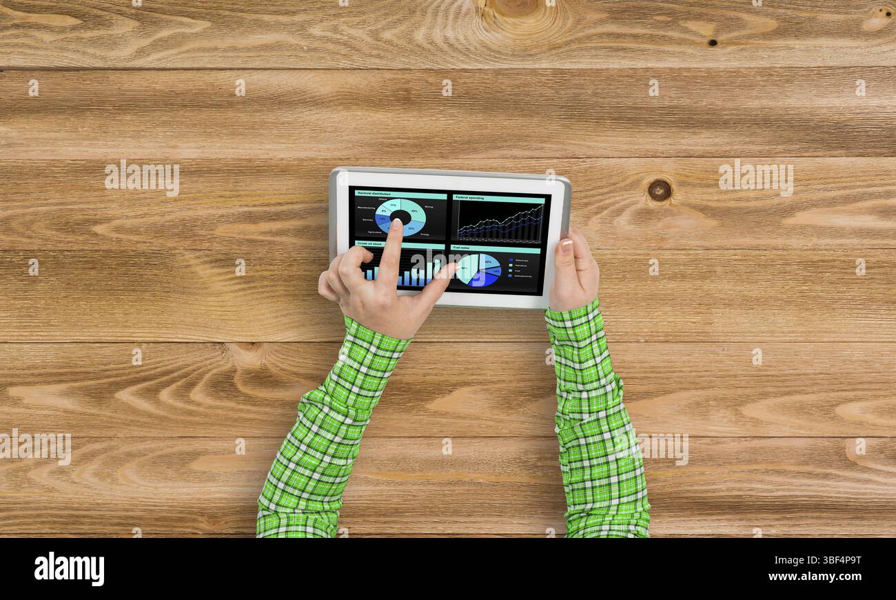 Vista superiore della ragazza mani con tablet pc con diagrammi e grafici sullo schermo Foto Stock