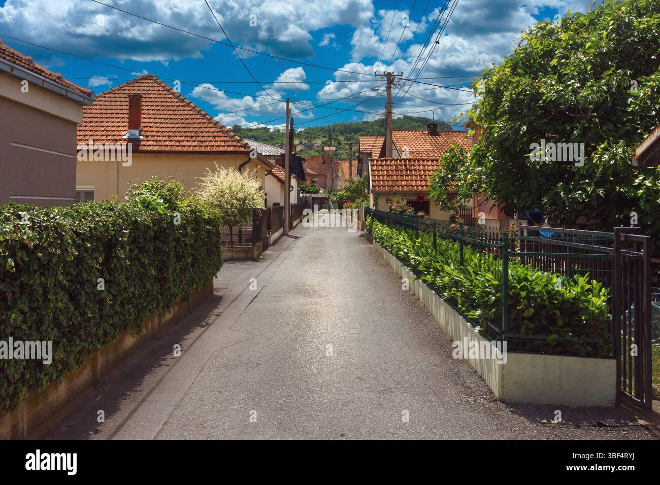 Una piccola strada cittadina in una città in Serbia, aspetto tipico di architettura e infrastrutture, nuvoloso giorno di sole in primavera. Foto Stock