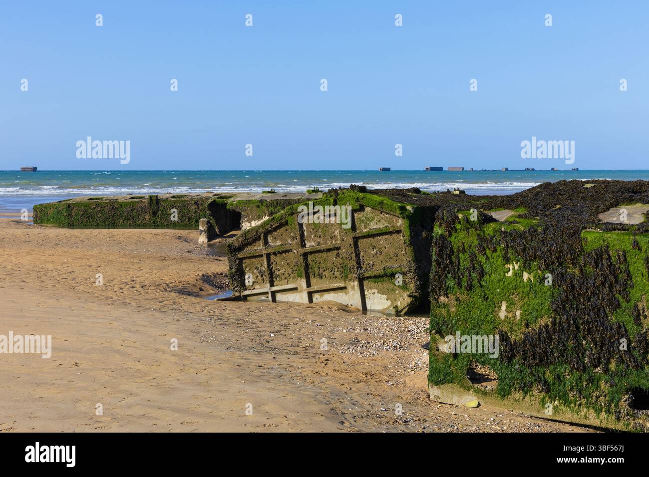 I resti di Mulberry Harbour B (Port Winston) utilizzati il D-Day per portare truppe, rifornimenti e veicoli ad Arromanches-les-Bains (Calvados), in Francia Foto Stock