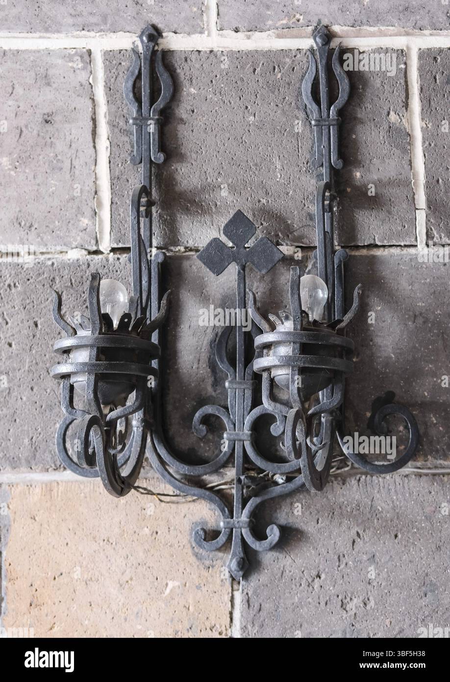 Lanterna in stile medievale appesa su un muro di pietra grigia Foto Stock