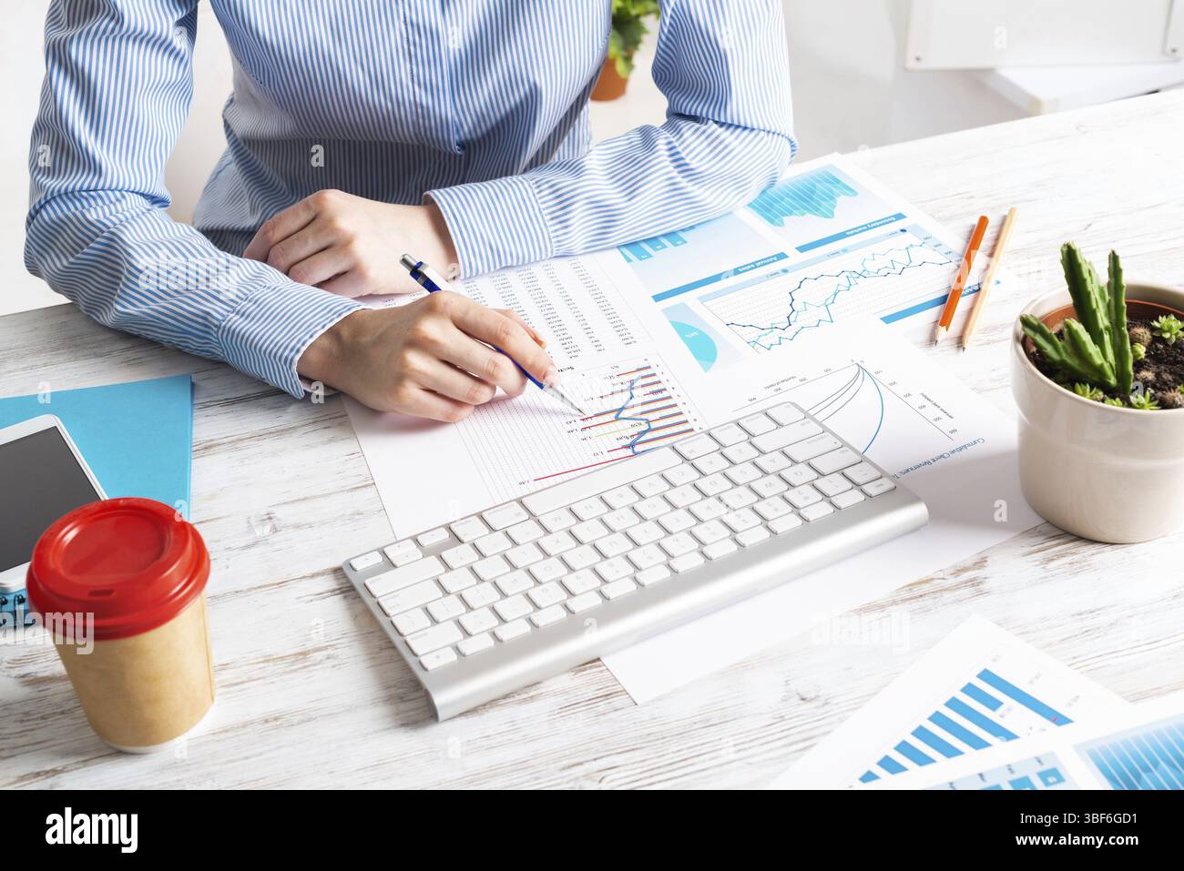 Consulente aziendale seduto alla scrivania e analizzato il rapporto finanziario. Pianificazione strategica e investimenti. Ufficio aziendale con analista presso Wooden Foto Stock