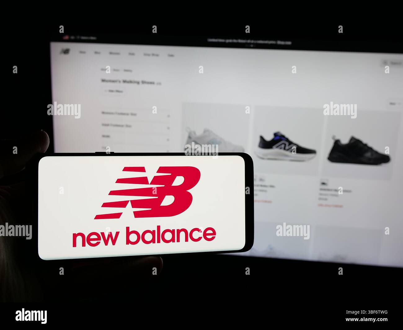 Germania. 7 maggio 2025. In questa immagine, una persona ha in mano uno smartphone con il logo della società statunitense New Balance Athletics Inc. (NB) sullo schermo davanti al sito Web. (Immagine di credito: © Timon Schneider/SOPA Images via ZUMA Press Wire) SOLO PER USO EDITORIALE! Non per USO commerciale! Foto Stock
