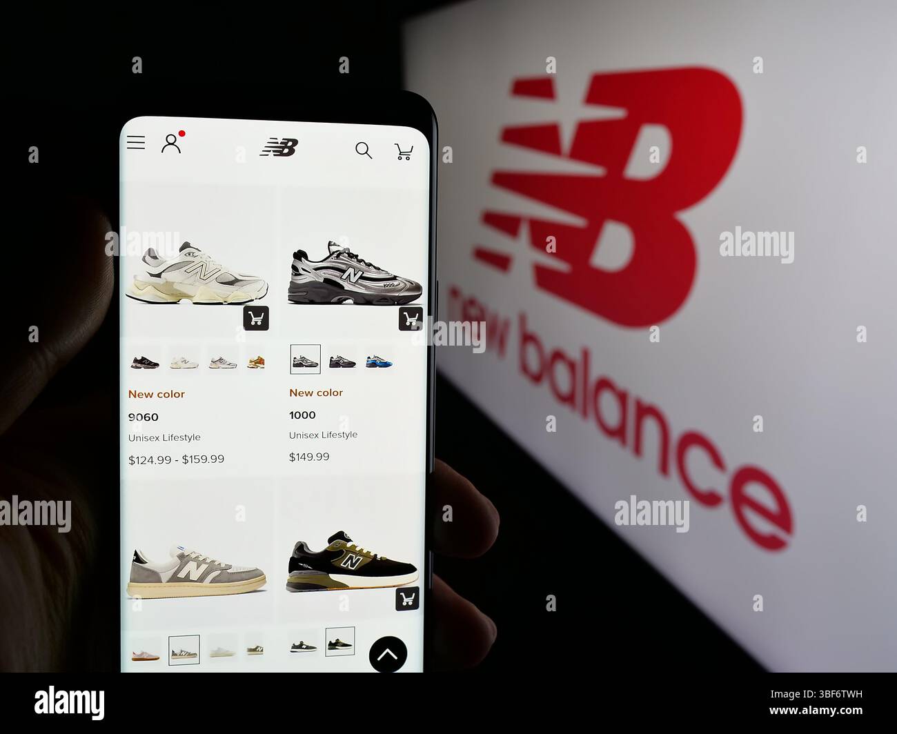 Germania. 7 maggio 2025. In questa immagine, una persona ha in mano una pagina Web con il logo della società statunitense New Balance Athletics Inc. (NB) sullo schermo davanti al logo. (Immagine di credito: © Timon Schneider/SOPA Images via ZUMA Press Wire) SOLO PER USO EDITORIALE! Non per USO commerciale! Foto Stock