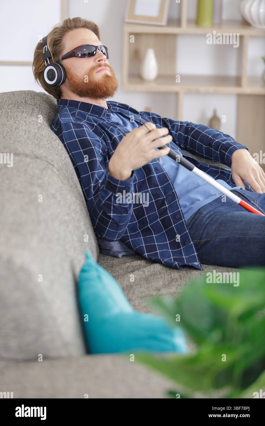 uomo cieco sul divano Foto Stock