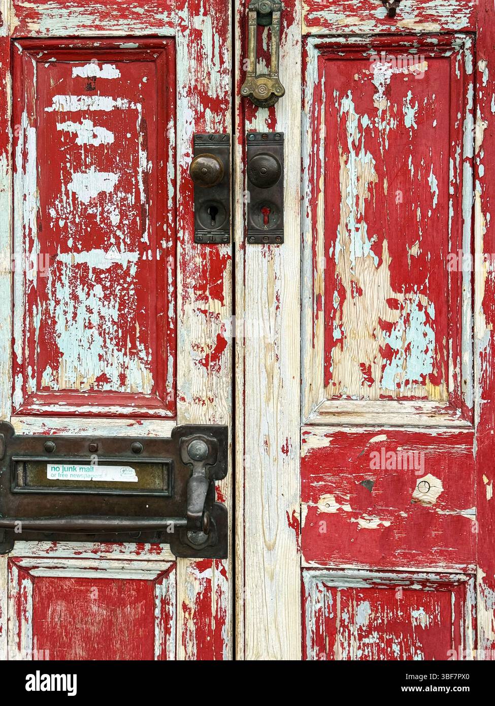 Una porta d'ingresso, vernice sbucciata e intemperie, ma con un fascino elegante e disinvolto - Immagine stock catturata con smartphone