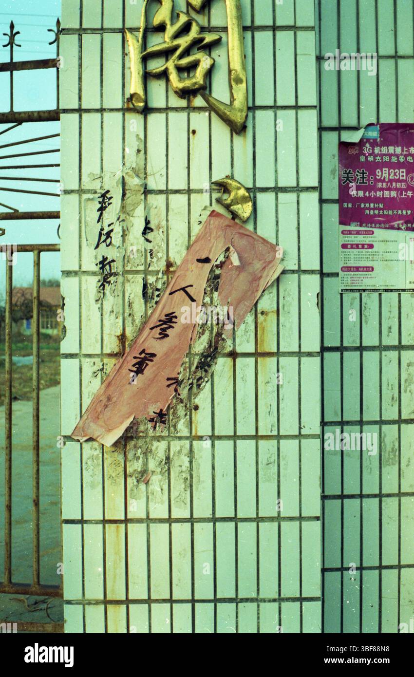 All'inizio degli anni '2010 poster di reclutamento militare di Xuzhou "uno si unisce all'esercito, tutta la famiglia onorata" sulla porta piastrellata Foto Stock